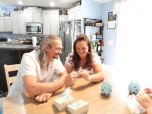 A man and a woman sitting and smiling at a dining room table